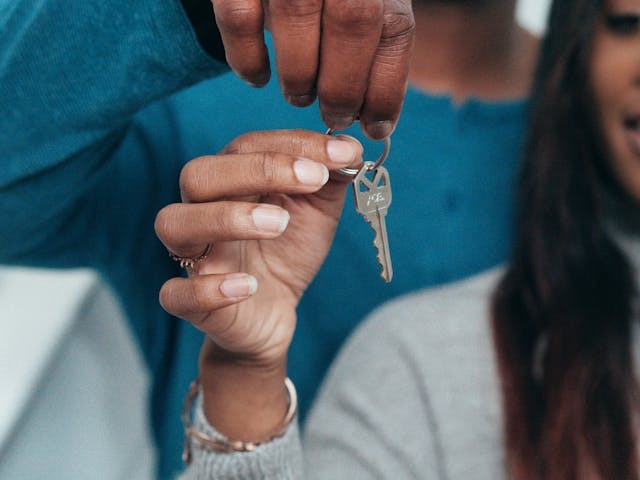 two people holding up a set of keys