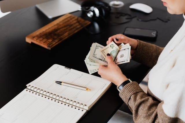 person counting a stack of money