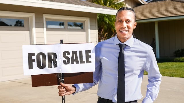 person holding a for sale sign